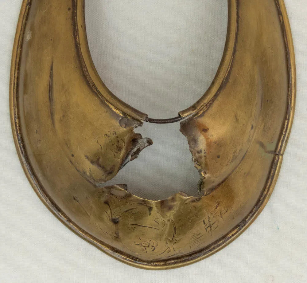 Front detail of a damaged gorget from the 20th Regiment